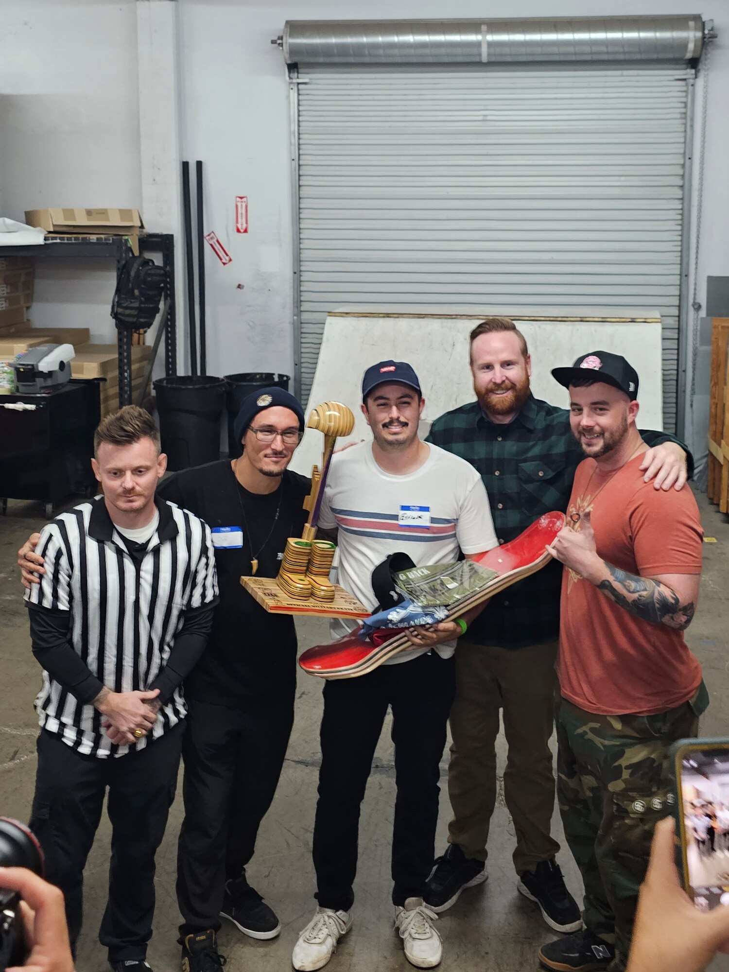 U.S. Air Force Staff Sgt. Erick Fregoso, center, 173rd Security Forces Squadron, celebrates with a group of friends while holding his trophy after winning the Official Military Skate competition.