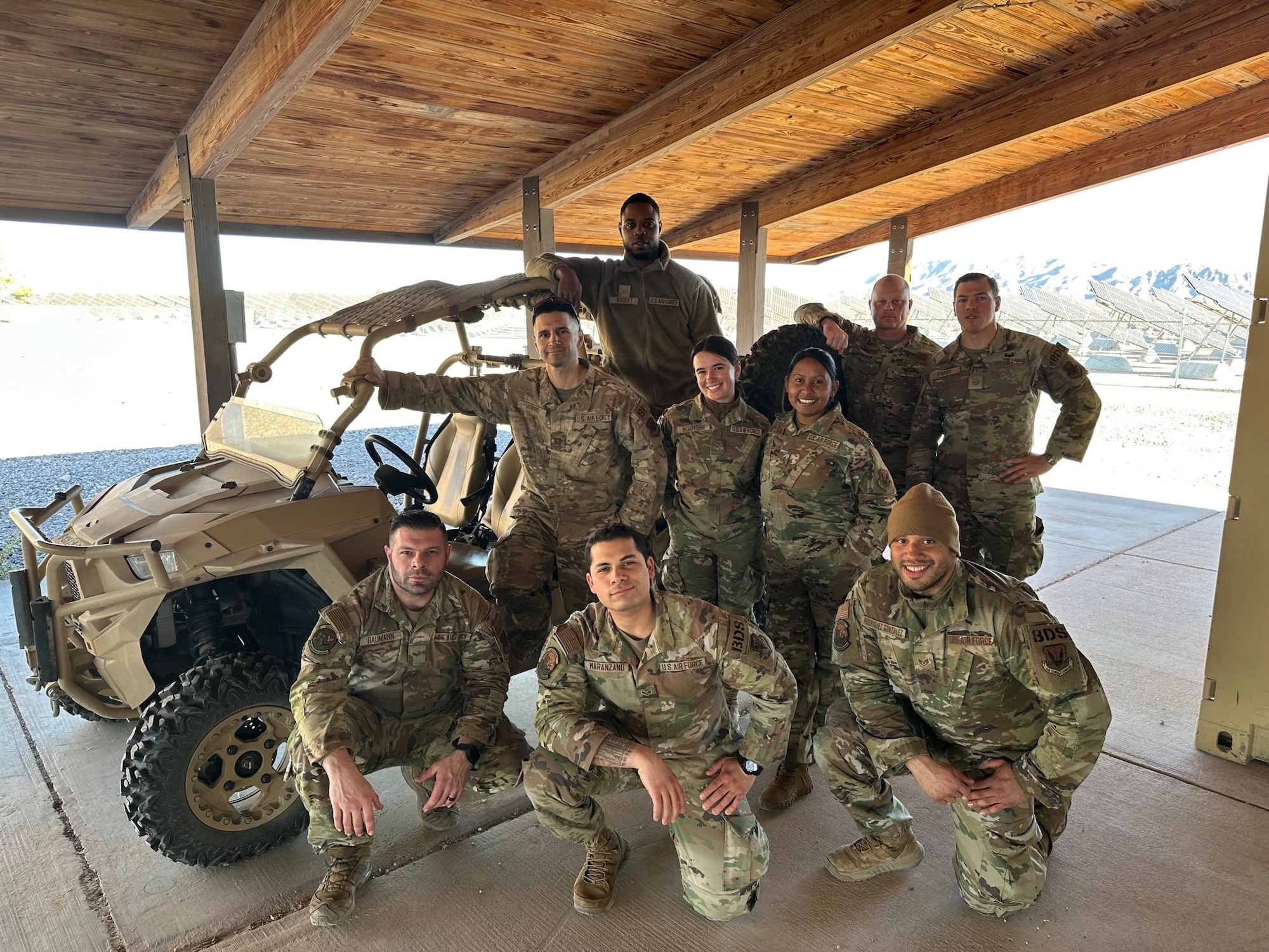 Guardsmen with the 105th Base Defense Squadron pose in front of an MRZR off road vehicle.