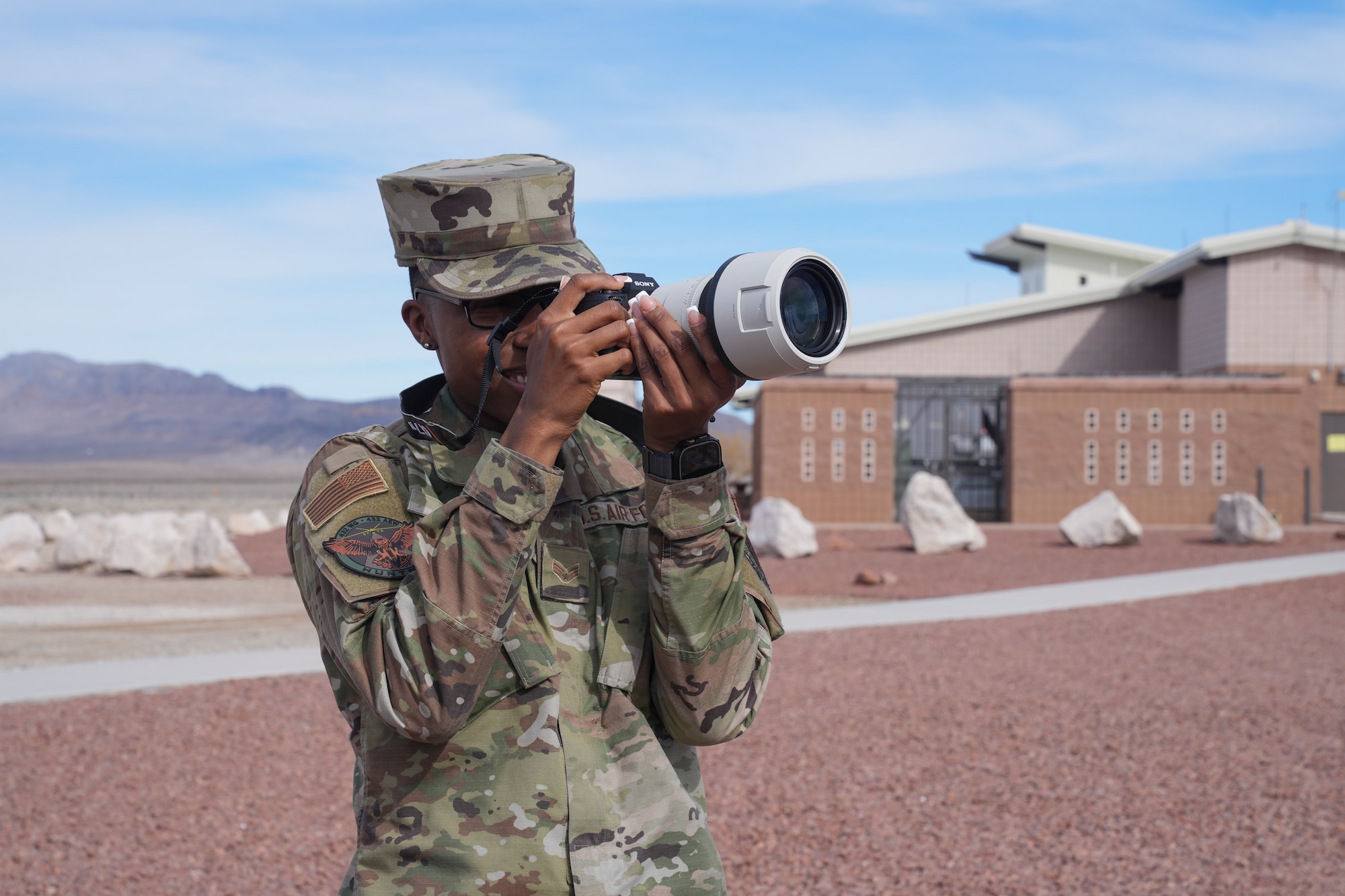 An airman taking a photo with a camera.