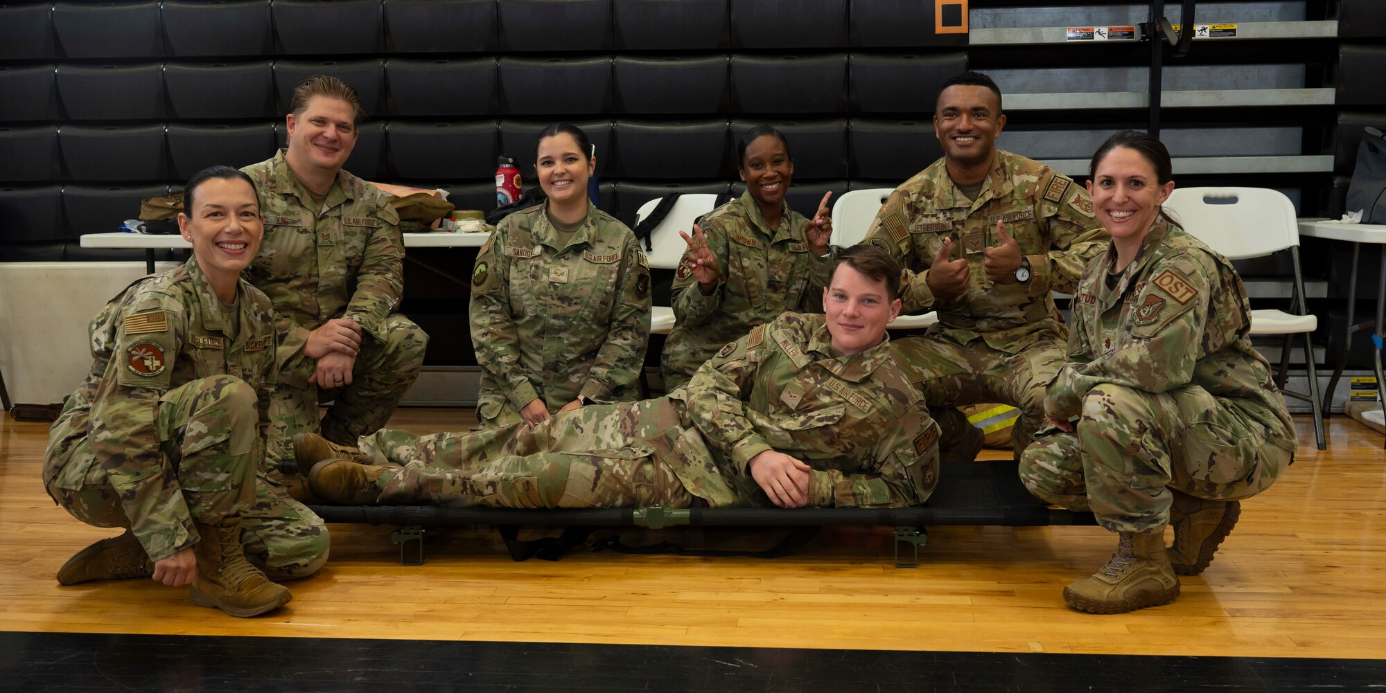 U.S. Air Force Airmen with the 36th Civil Engineer Squadron and 36th Medical Group pose for a photo during the Tiyan High School Health Fair in Barrigada, Guam, Feb. 23, 2024. At the fair the Airmen demonstrated carrying a patient, applying a tourniquet, and walked students through various physical therapy exercises. (U.S. Air Force photo by Airman 1st Class Spencer Perkins)