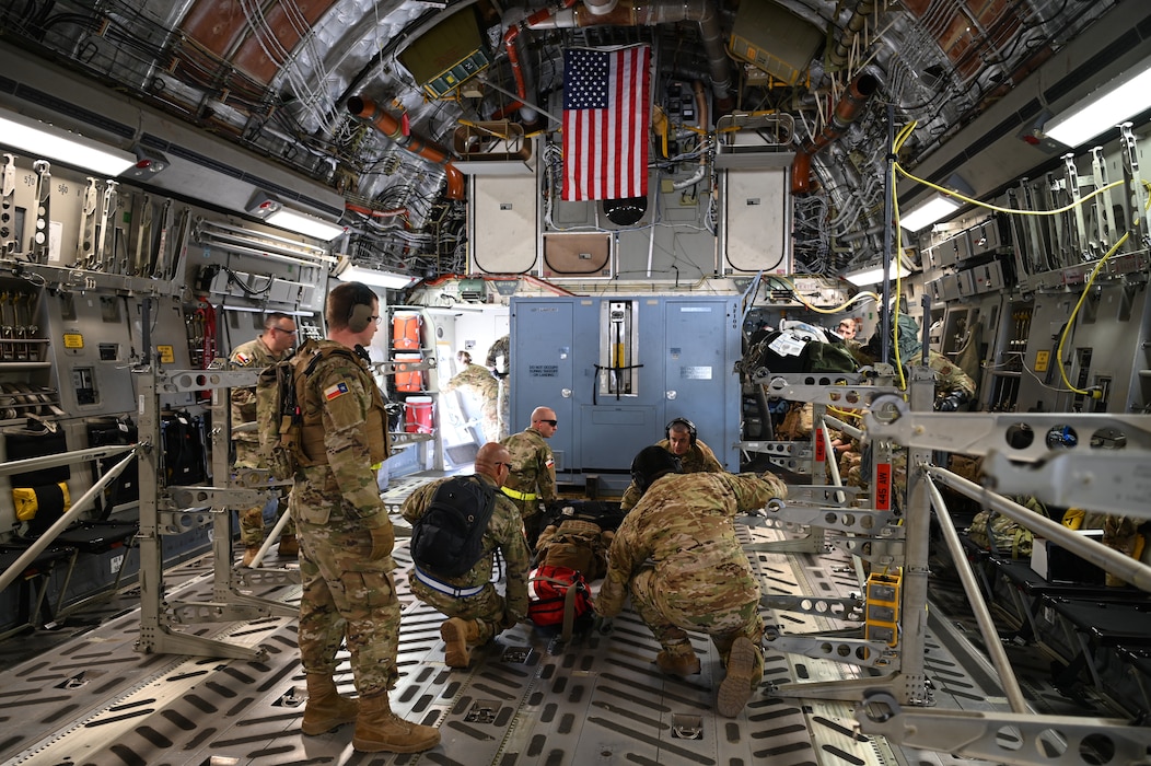 433rd Aeromedical Evacuation Squadron Airmen and Texas State Guardsmen of the 1st Battalion, 6th Brigade work together to load a simulated patient aboard a C-17 Globemaster during joint medical training at Joint Base San Antonio-Lackland, Texas on Feb. 24, 2024.