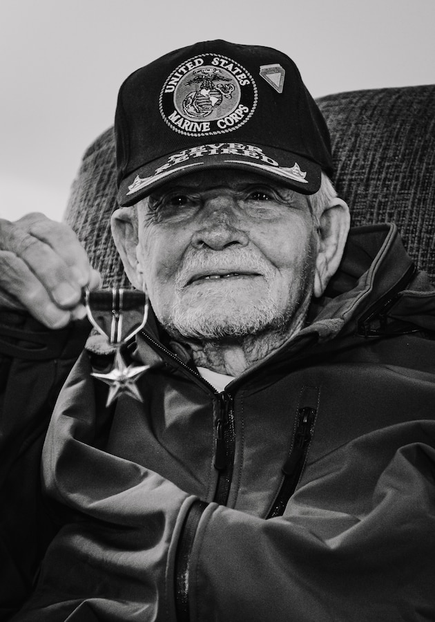 Retired U.S. Marine Corps Staff Sgt. Ismael Gonzalez-Ramos, a former infantry unit leader and decorated combat veteran, holds his Bronze Star medal with a combat action “V” device, an award for valor and heroism in combat, at his home in Jacksonville, North Carolina, Nov. 20, 2023. 92-year-old Gonzales-Ramos was drafted from Cidra, Puerto Rico in 1951 and served in the Korean War and Vietnam War during his 20 years of honorable service in the Marine Corps. (U.S. Marine Corps photo by Lance Cpl. Loriann Dauscher)