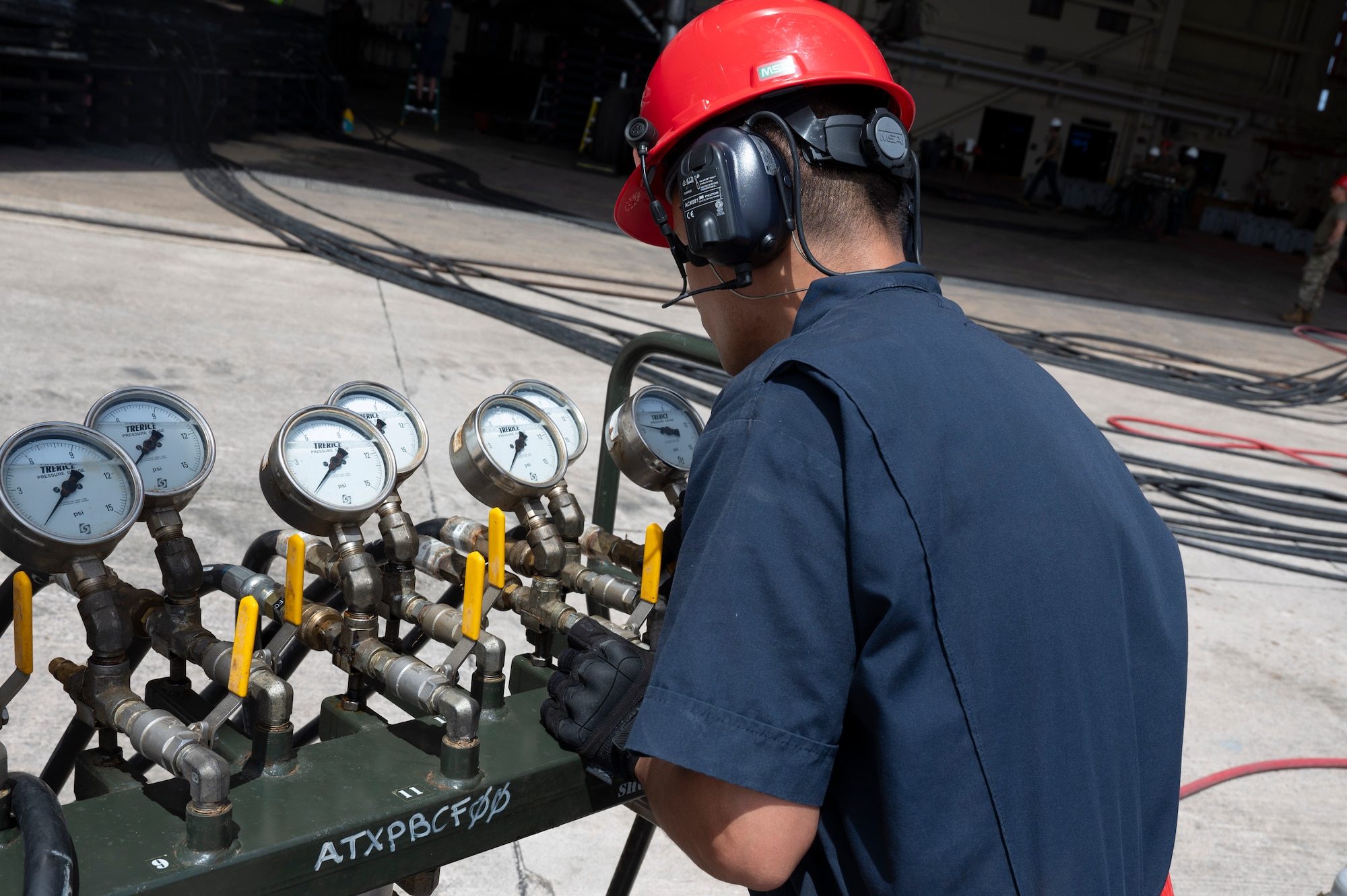 U.S. Air Force Master Sgt. Peter Leon Guerrero, 36th Maintenance Squadron production superintendent, monitors a pressure manifold module while inflating low pressure heavy aircraft lifting bags to lift an A310 aircraft on Andersen Air Force Base, Guam, Feb. 22, 2024. The Airmen had to lift the aircraft so that contractors could use an excavator to demolish it due to unrepairable damages. (U.S. Air Force Photo by Airman 1st Class Spencer Perkins)