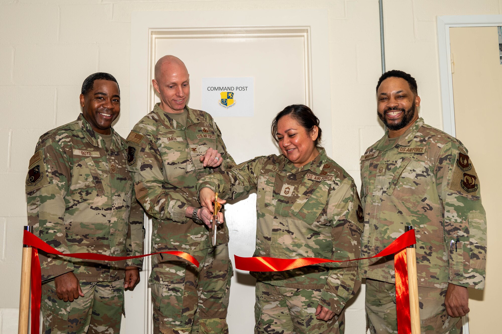 Four members gather to cut a ribbon together.