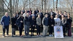 A group of conference attendees pose outside for a photo.