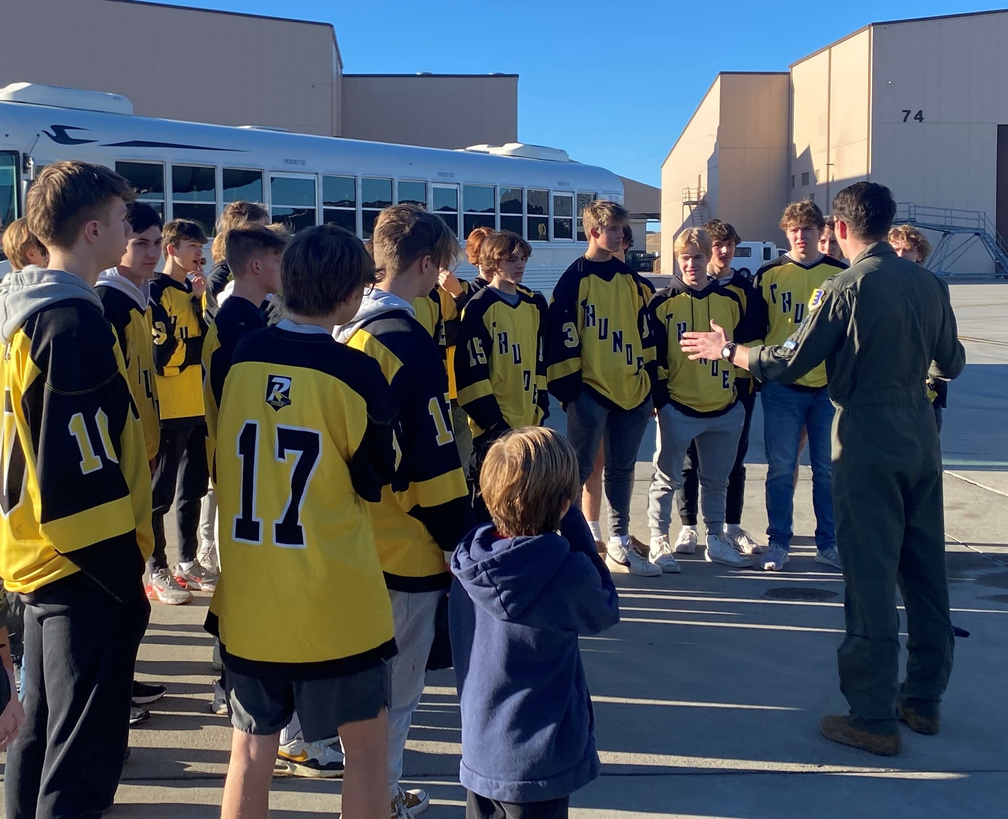 High school hockey players pose by B-1