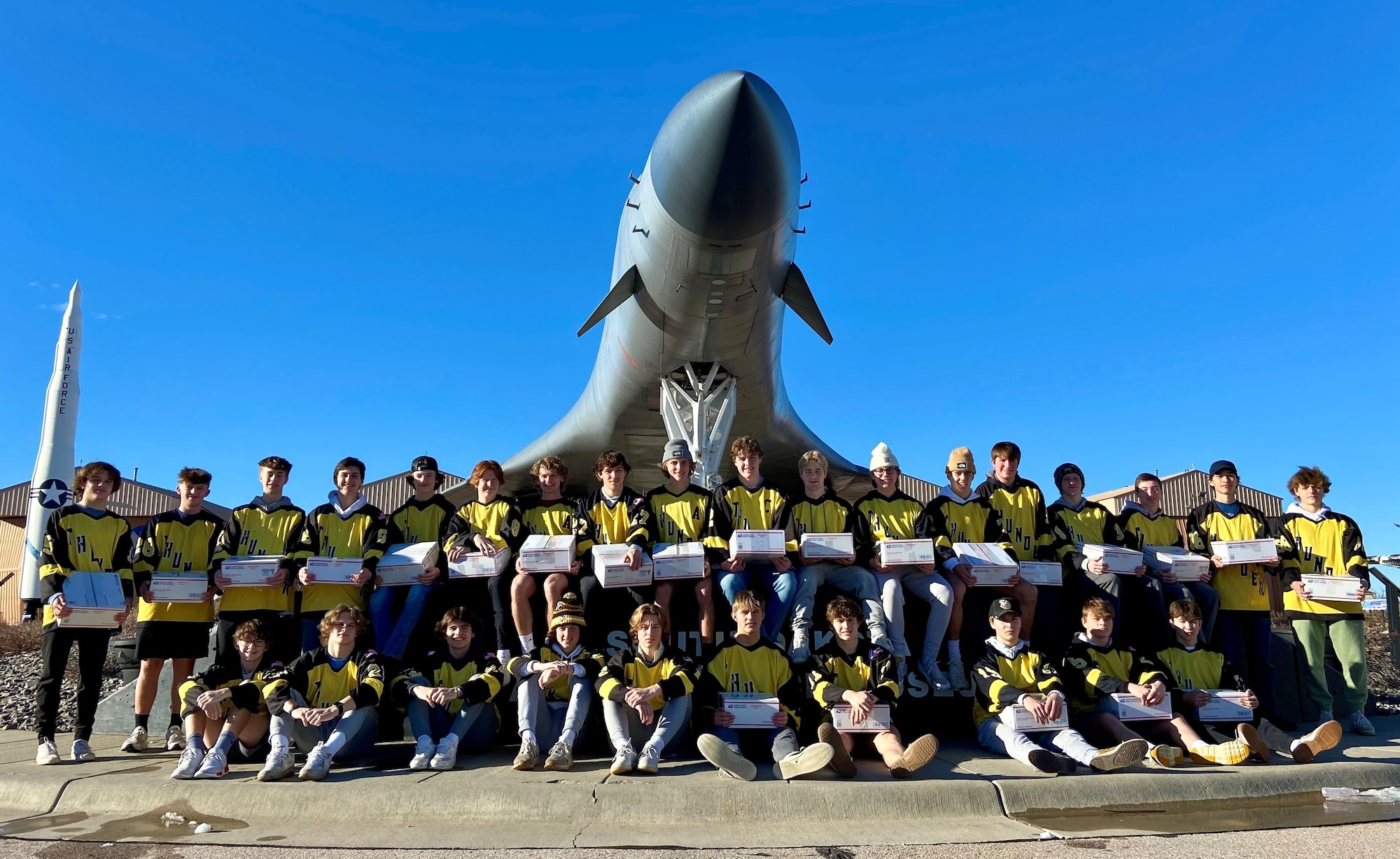 High school hockey players pose by B-1