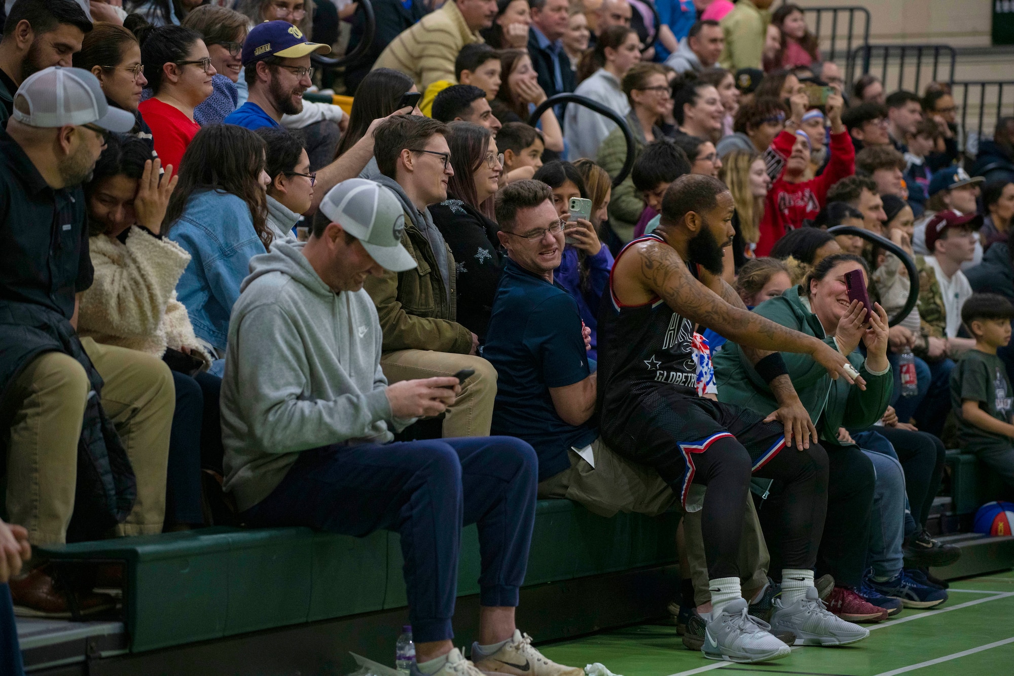 Darnell “Speedy” Artis, Harlem Globetrotters guard, left, takes a seat on an unsuspecting spectator at RAF Alconbury