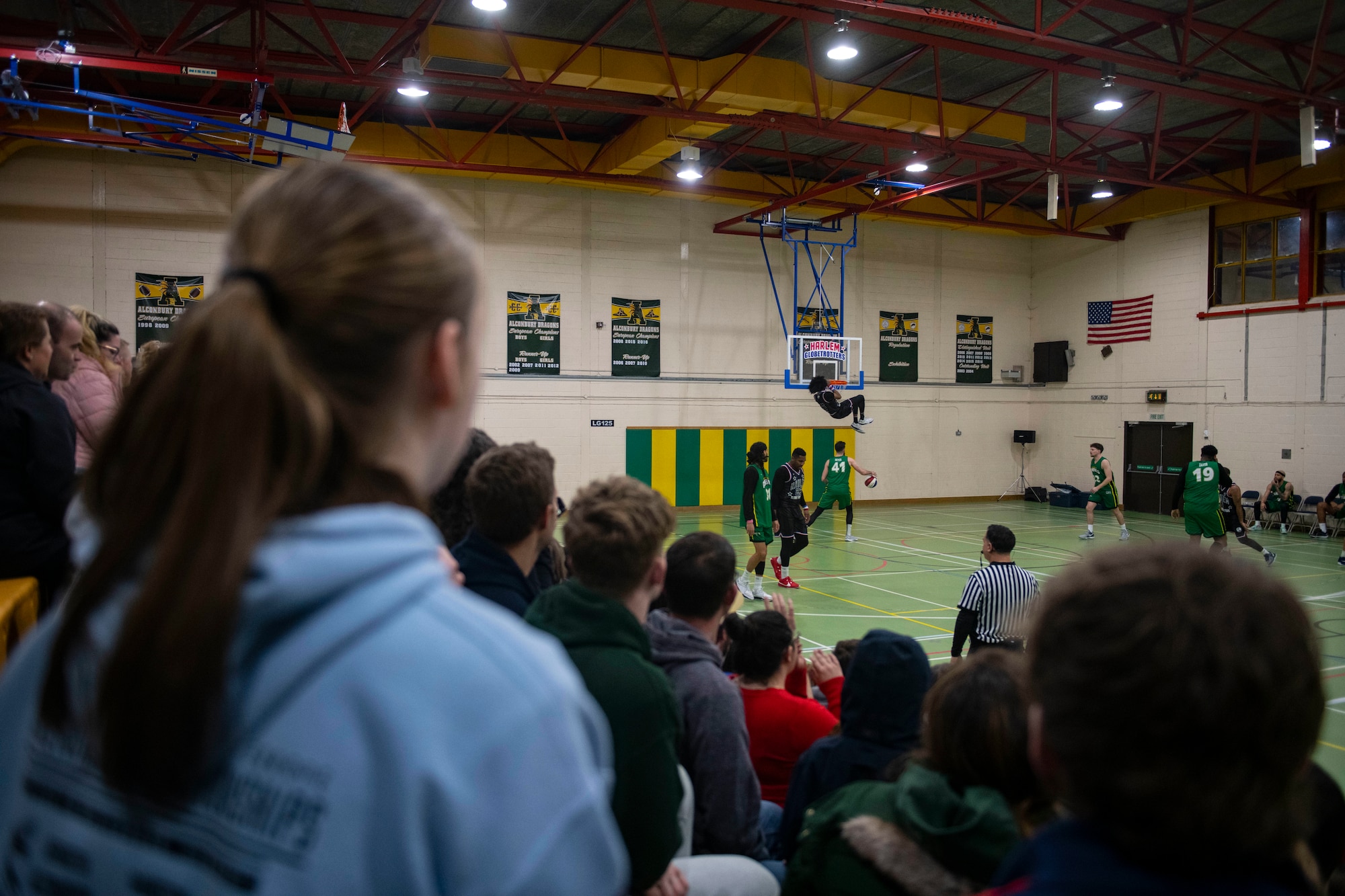 The audience watches as a member of the Harlem Globetrotters dunks at RAF Alconbury
