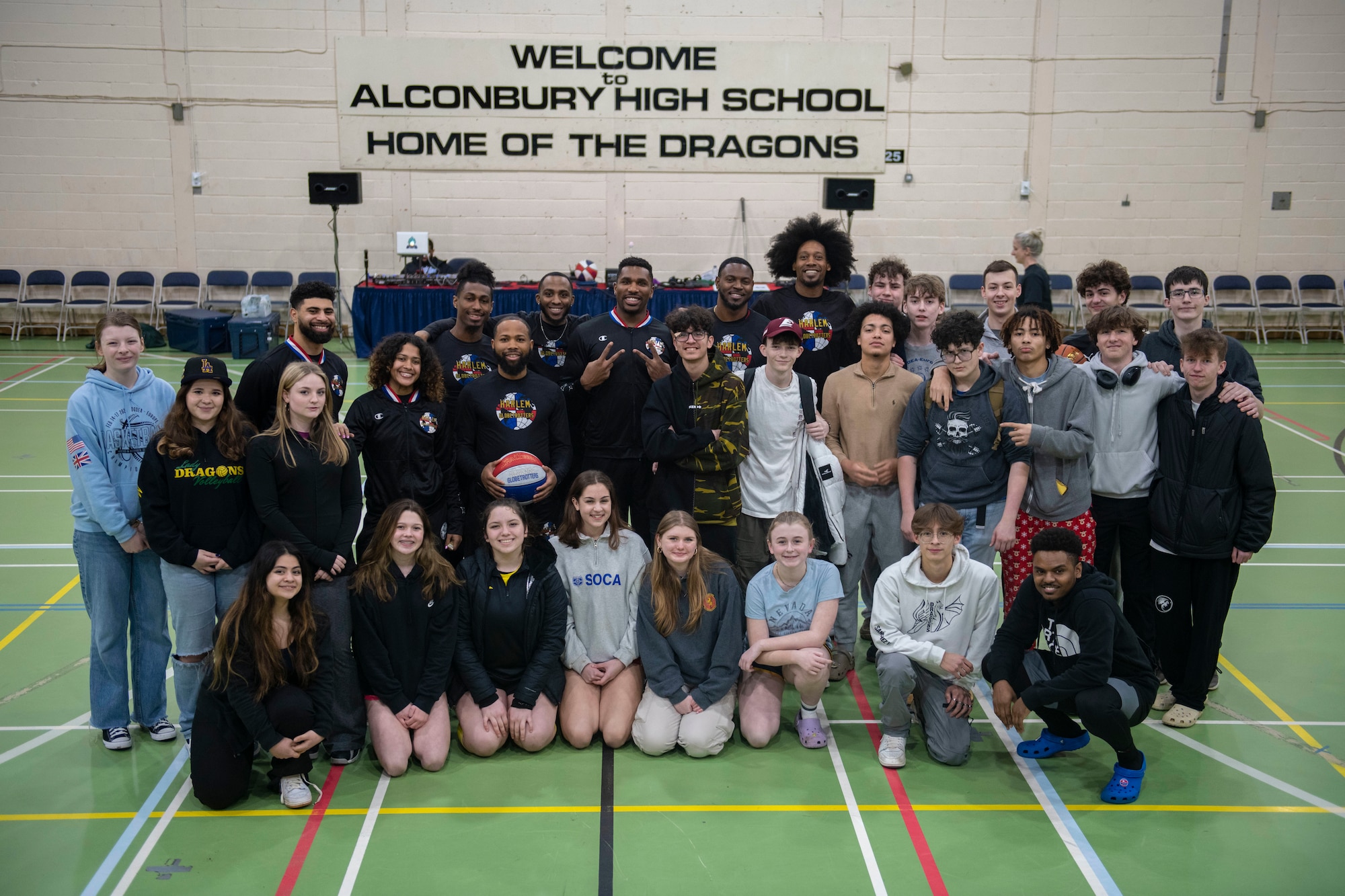 The Harlem Globetrotters pose for a photo with basketball players from RAF Alconbury Middle High School at RAF Alconbury