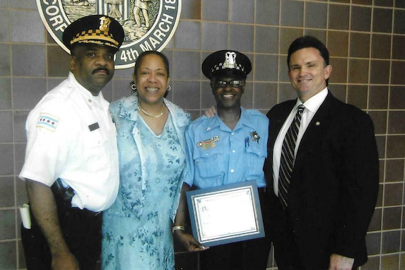 Chicago Police Officer and Army Reserve Soldier Diane Mason, third from left, pauses for a photo after receiving an award for outstanding Police work with Chicago Police Commander Eddie Johnson, left, and former Chicago Police Superintendent Jody Weis, right.