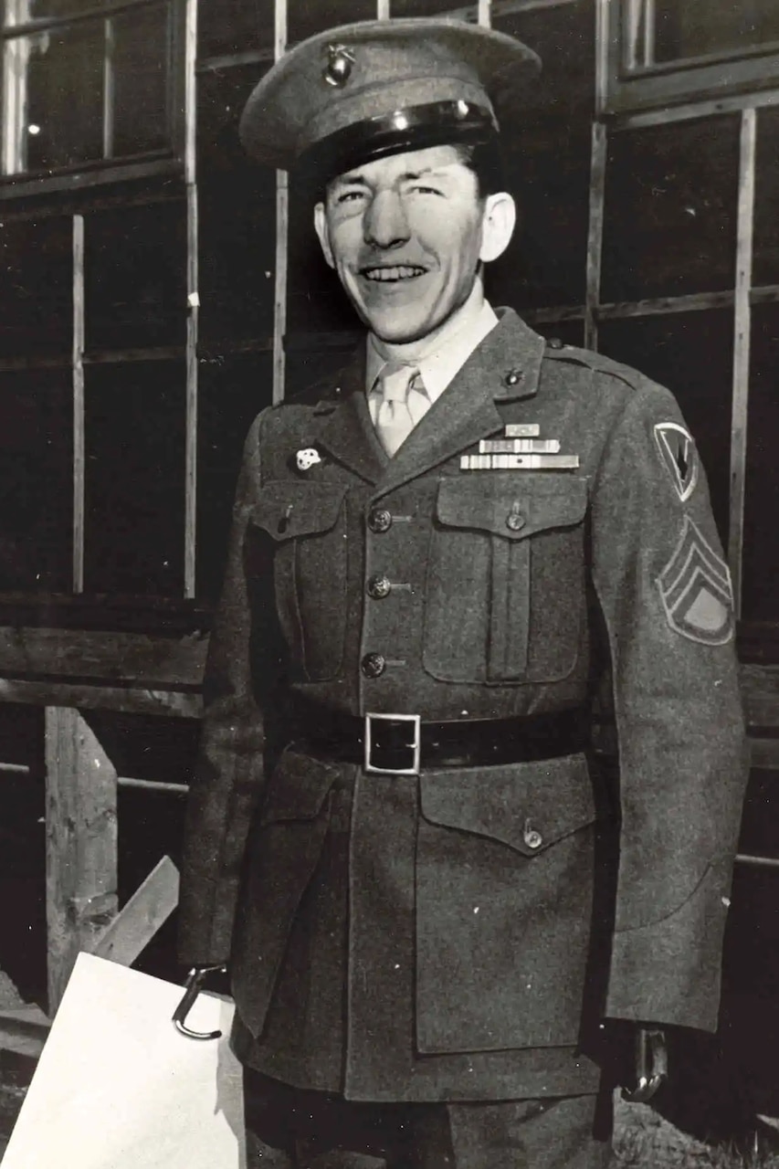 A person in a military uniform smiles for a photo.