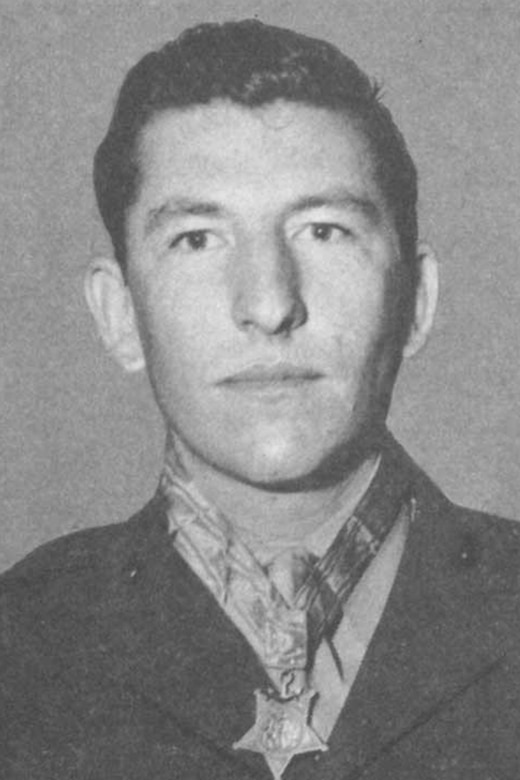 A person wearing a medal around their neck poses for a black and white photo.