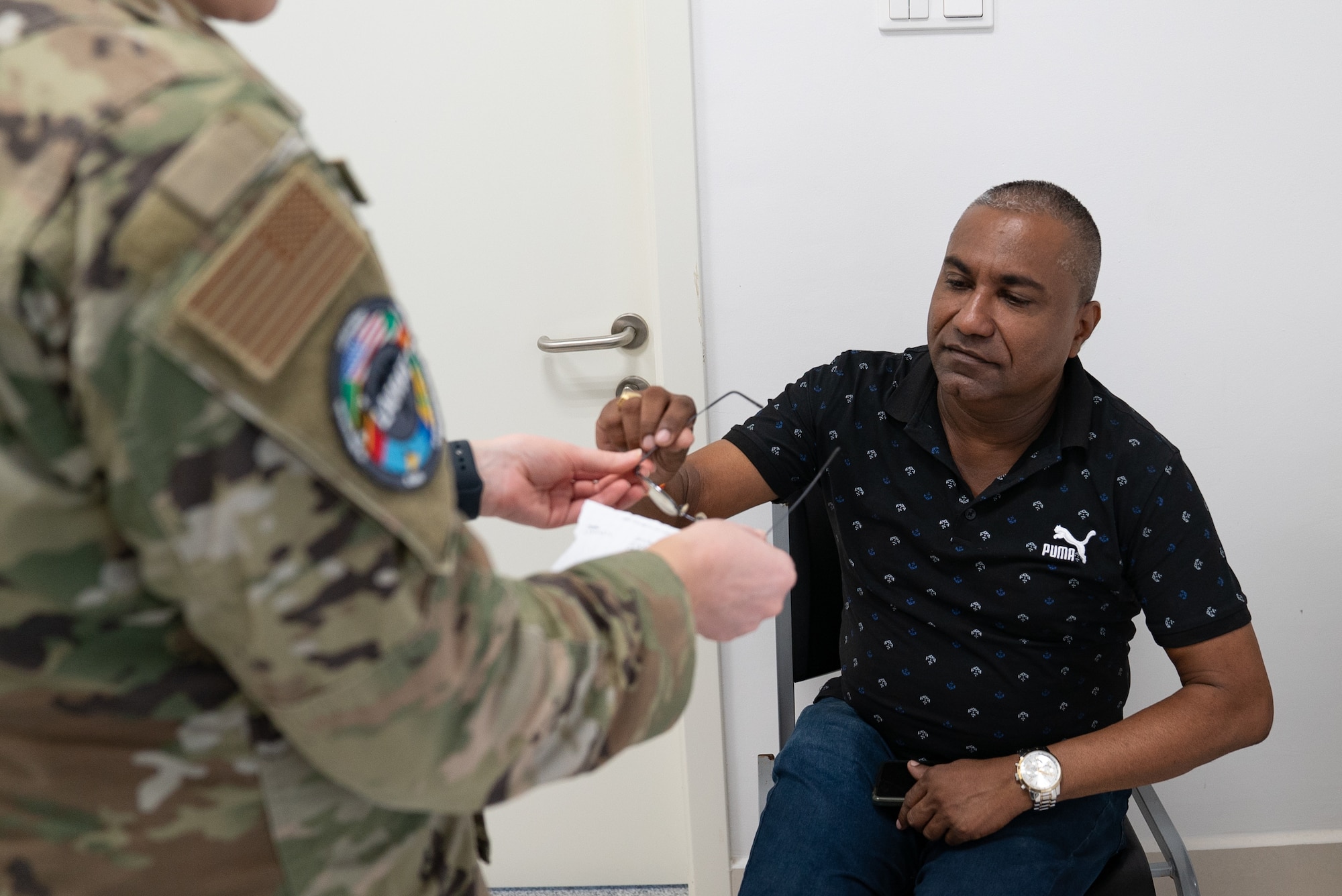 U.S. Air Force Master Sergeant Stacey Kinney, 512th Aerospace Medical Squadron optometry specialist, provides prescription eyeglasses to a patient at Regional Hospital Wanica, Wanica District, during the Lesser Antilles Medical Assistance Team mission in Suriname, Feb. 21, 2024.