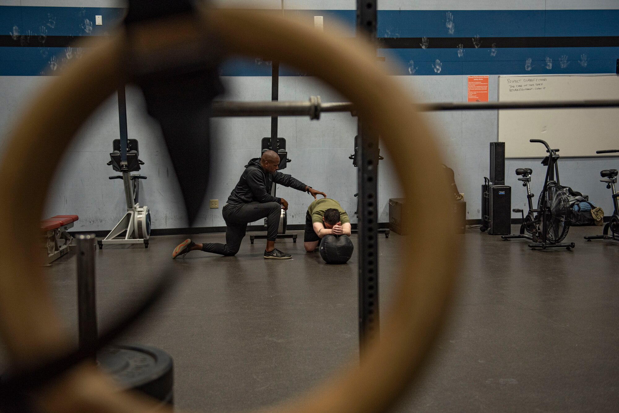 A coach helps with posture during a workout