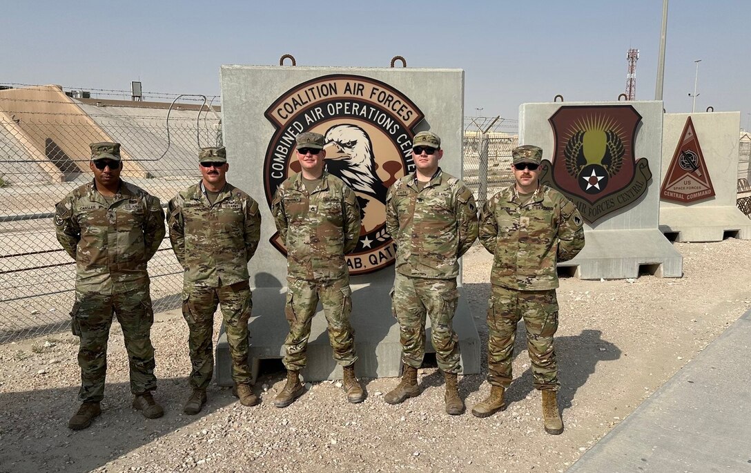 Maj. Tyler Brown, Chief Warrant Officer 4 Jody Lyddane, Staff Sgt. Matthew Beverly, Staff Sgt. Earnest Cansler III, Staff Sgt. Zane Caudill pose for a team photo at the Combined Air & Space Operations Center, Al Udeid Air Base, Qatar.
