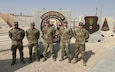 Maj. Tyler Brown, Chief Warrant Officer 4 Jody Lyddane, Staff Sgt. Matthew Beverly, Staff Sgt. Earnest Cansler III, Staff Sgt. Zane Caudill pose for a team photo at the Combined Air & Space Operations Center, Al Udeid Air Base, Qatar.
