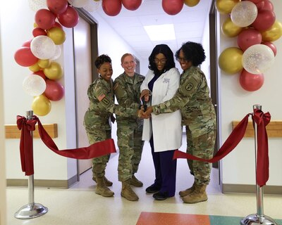 Lt. Col. Tanekkia Taylor-Clark, Capt. Holly Flanscha, Kim Howard and Lt. Col. Monique Grinnell cut the ribbon during the Clinical Nurse Transition Program (CNTP) program accreditation celebration, February 16, 2024. Womack Army Medical Center is the second military treatment facility to receive this distinction