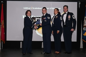 U.S. Air Force Chief Master Sgt. Alex J. Eudy, Senior Non-Commissioned Officer Academy commandant receives a check from The Fisher House Foundation, a non-profit organization, to donate to a charity of his choice during the Annual Awards Ceremony at the First Finacial Pavilion, San Angelo, Texas Feb. 24, 2023. Fisher House Foundation is an international, nonprofit established to improve the quality of life for members of the military, veterans, and their families. (U.S. Air Force photo by Airman James Salellas)