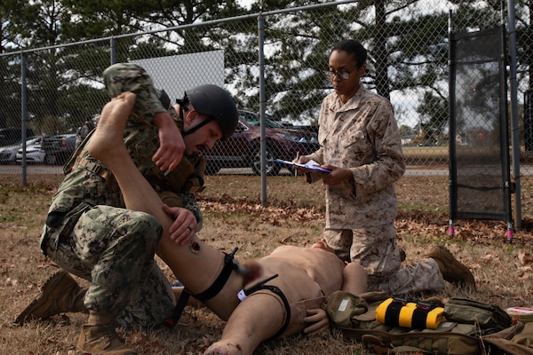 240126-N-KC192-1220 PORTSMOUTH, Va. (Jan. 26, 2024) Hospital Corpsman 2nd Class William Wiegmann, a general duty corpsman assigned to Navy Region Readiness and Mobilization Command (REDCOM) Norfolk, stabilizes the leg of a simulated patient while Chief Hospital Corpsman Tianna Blackmon, an active duty for operational support reservist and Naval Medical Forces Atlantic (NMFL) regional reserve program director, evaluates his knowledge during a Tactical Combat Casualty Care (TCCC) Tier 3 "Train the Trainer" and pilot course on board Naval Support Activity (NSA) Hampton Roads - Portsmouth Annex, Jan. 26, 2024. The two-week course certified 15 TCCC providers that were also able to provide in-depth feedback on course improvements. TCCC Tier 3 is a combat medic course that provides in-depth life saving techniques, technical information and strategies for Department of Defense first responders, and ensures students receive the necessary hands-on training experience that is required for U.S. Navy medical forces to maintain deployment readiness. (U.S. Navy photo by Mass Communication Specialist 2nd Class Levi Decker)