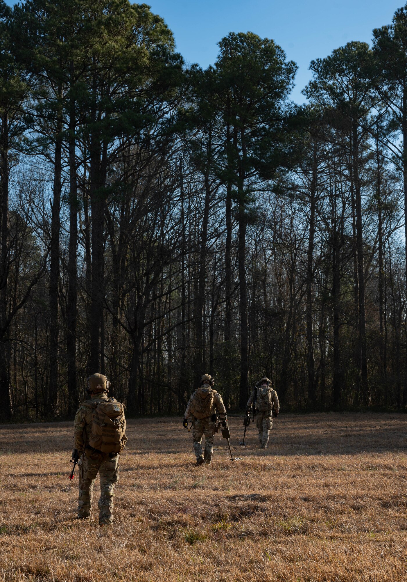 U.S. Airmen assigned to the 4th Civil Engineer Squadron sweep a field for explosive devices during a simulated response exercise at Seymour Johnson Air Force Base, North Carolina, Feb. 22, 2024. Over the course of the exercise, participants practiced recovering downed pilots, located sensitive components and transported high value explosive items while maintaining security in a simulated hostile environment. (U.S. Air Force Photo by Airman 1st Class Rebecca Sirimarco-Lang)
