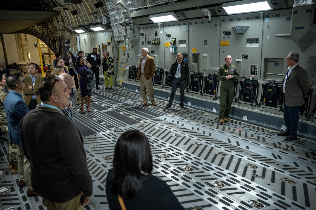 Maj. Stacie Wrobel gives a briefing inside a cargo bay full of tour attendees.