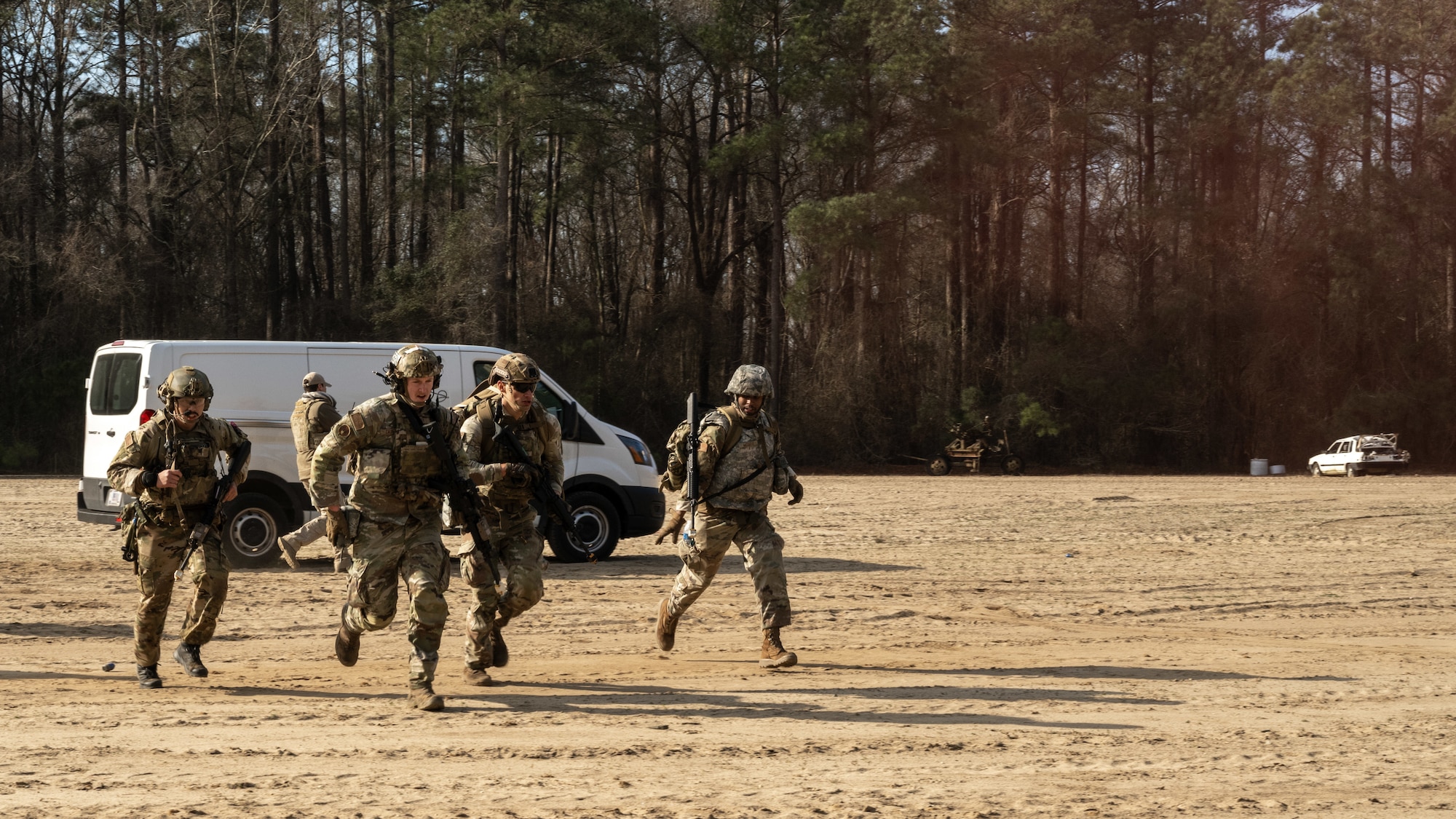 U.S. Airmen assigned to the 4th Civil Engineer Squadron advance to a position for a mock helicopter rescue during a simulated response exercise at Seymour Johnson Air Force Base, North Carolina, Feb. 22, 2024. The training tested the squadron’s ability to properly respond to an aircraft crash under strenuous conditions and brought several different organizations across base together to maximize a realistic atmosphere and maintain security. (U.S. Air Force Photo by Airman Rebecca Tierney)