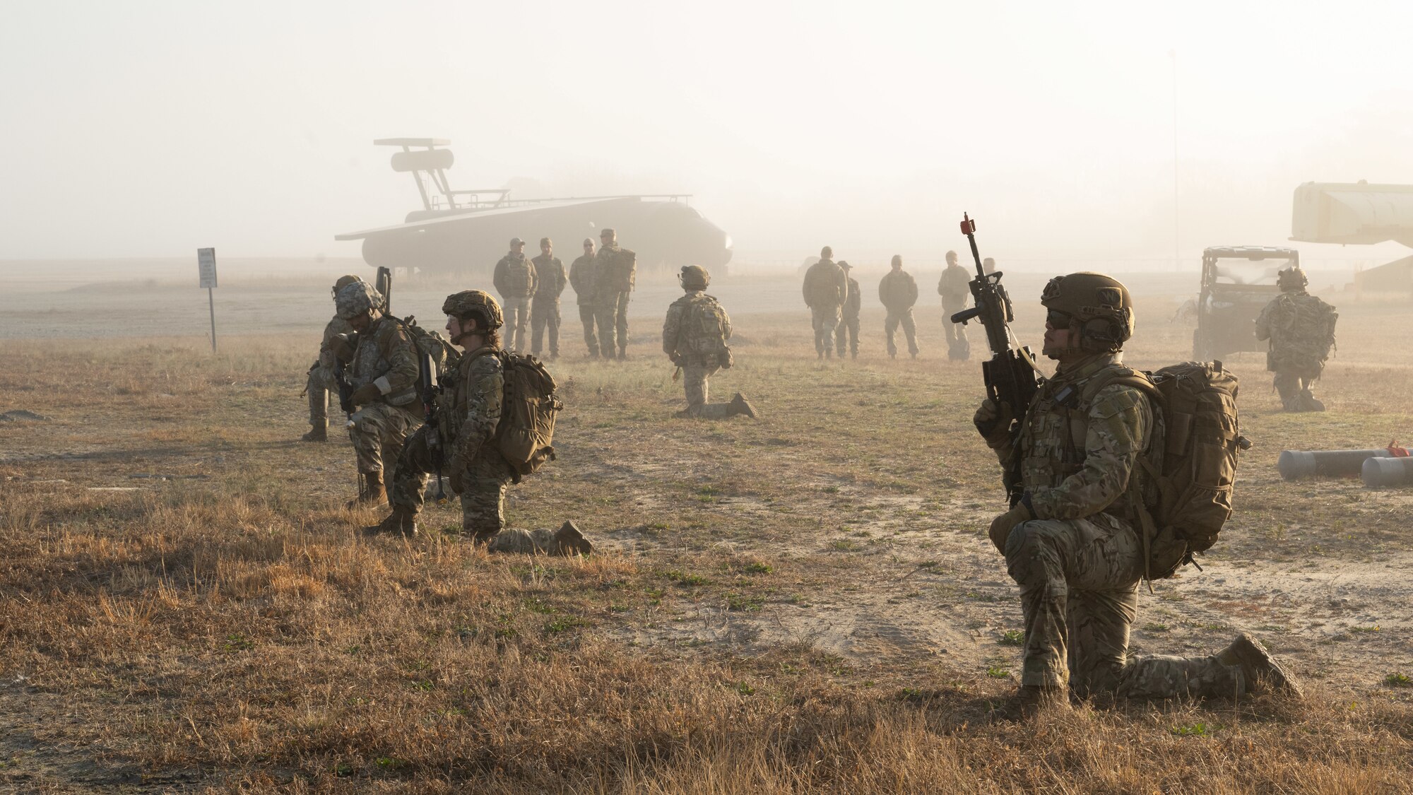 U.S. Airmen assigned to the 4th Civil Engineer Squadron kneel while awaiting orders during a simulated response exercise at Seymour Johnson Air Force Base, North Carolina, Feb. 22, 2024. Over the course of the exercise, participants practiced recovering downed pilots, located sensitive components and transported high value explosive items while maintaining security in a hostile environment. (U.S. Air Force Photo by Airman Rebecca Tierney)