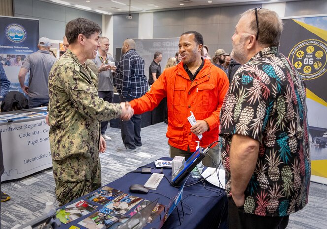 Capt. JD Crinklaw, commander, Puget Sound Naval Shipyard & Intermediate Maintenance Facility, shakes hands with Dwight Stephens, a job applicant from Bremerton, Washington, Feb. 23, 2024, during a two-day PSNS & IMF Hiring Fair at the Kitsap Conference Center in downtown Bremerton. (U.S Navy photo by Wendy Hallmark)