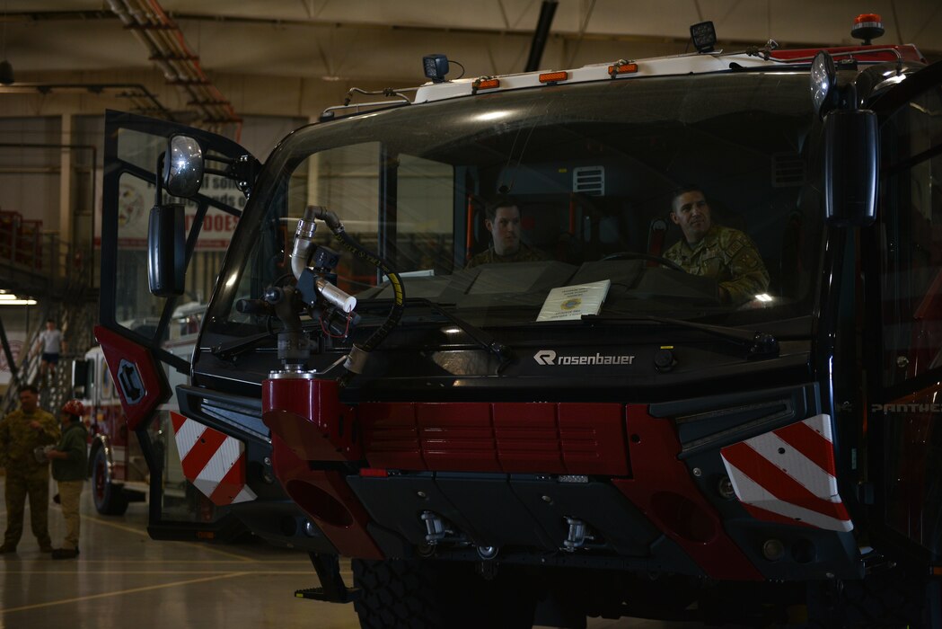 U.S. Air Force Chief Master Sgt. Alex J. Eudy, Senior Non-Commissioned Officer Academy commandant, sits in the driver's cab with Master Sgt. Anthony Montano, 312th Training Squadron fire chief, at Goodfellow Air Force Base, Texas, Feb. 22, 2024. Montano briefed about the differences between the various fire trucks used during training (U.S. Air Force photo by 2nd Lt. Kayunna Holt)
