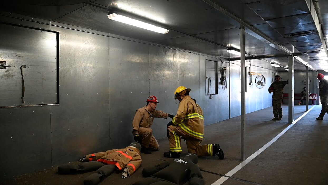 U.S. Air Force Chief Master Sgt. Alex J. Eudy, Senior Non-Commissioned Officer Academy commandant, receives instructions from Tech. Sgt. Robert Powell, 312th Training Squadron Instructor, on how fire protection students are trained to properly execute a fireman’s drag at Goodfellow Air Force Base, Texas, Feb. 22, 2024. Joint service students at the Louis F. Garland Department of Defense Fire Academy are trained to don their gear in less than 60 seconds. (U.S. Air Force photo by Airman James Salellas)