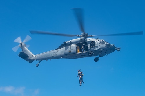A U.S. Navy MH-60S Knighthawk recovers simulated survivors, the Science and Engineer Demand Force Team-built dummy, during Cope North 24 off the coast of Guam Feb. 20, 2024. Cope North provides an optimal environment to enhance possible opportunities for long-term advancement of shared interests. (U.S. Air Force photo by Senior Airman Cedrique Oldaker)