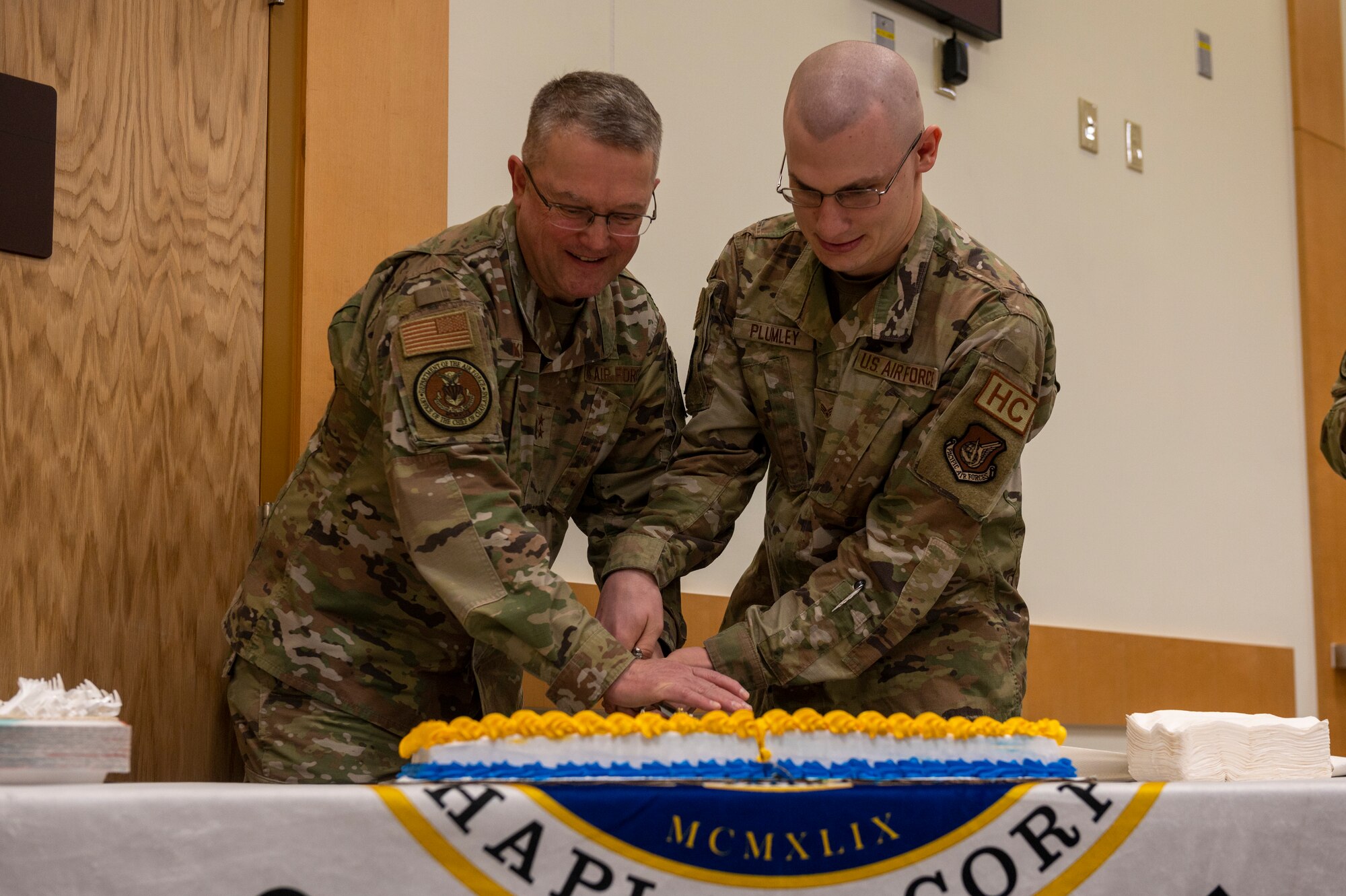 U.S. Air Force Maj. Gen. Randall Kitchens, Department of the Air Force chief of chaplains, and Senior Airman Aaron Plumley, 51st Fighter Wing religious affairs airman, cut a cake during the Osan Air Base Chapel Grand Opening Ceremony at Osan AB, Republic of Korea, Feb. 29, 2024. Service members celebrated the opening of the new chapel as well as the 75th birthday of the Air Force Chaplain Corps. The new chapel commits to maintaining its service to Airmen for the next 50 years, demonstrating an investment in Osan today for the Airmen of tomorrow. (U.S. Air Force photo by Senior Airman Kaitlin Castillo)