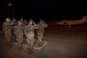 People salute plane carrying the General.