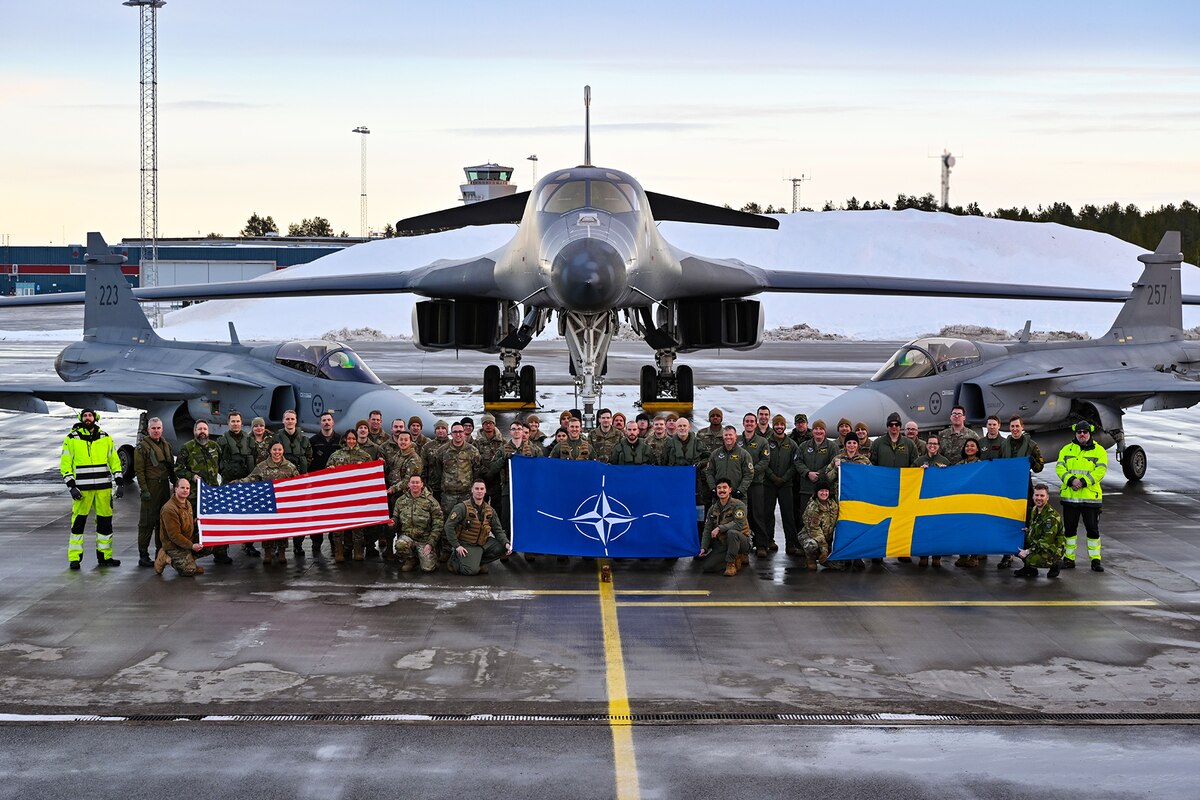 Air Force Airmen assigned to the 28th Bomb Wing, Ellsworth Air Force Base, South Dakota, pose for a group photo alongside Swedish military personnel in front of a B-1B Lancer and two Saab JAS 39 Gripens at Luleå-Kallax Air Base, Sweden, Feb. 26, 2024, during Bomber Task Force 24-2.