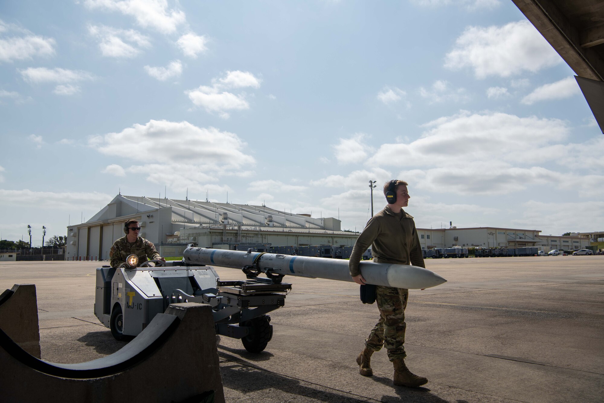 Two Airmen move munitions on the Kadena flightline.