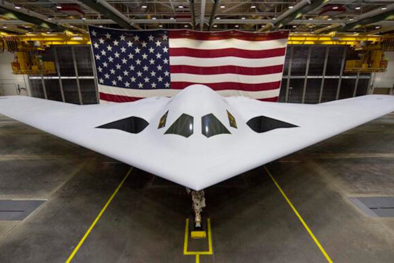 An aircraft is displayed with a U.S. flag in the background.