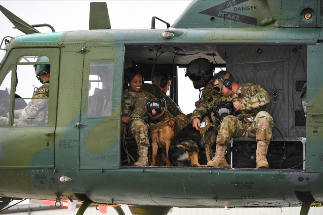 Security forces members sit in a helicopter ready for takeoff.