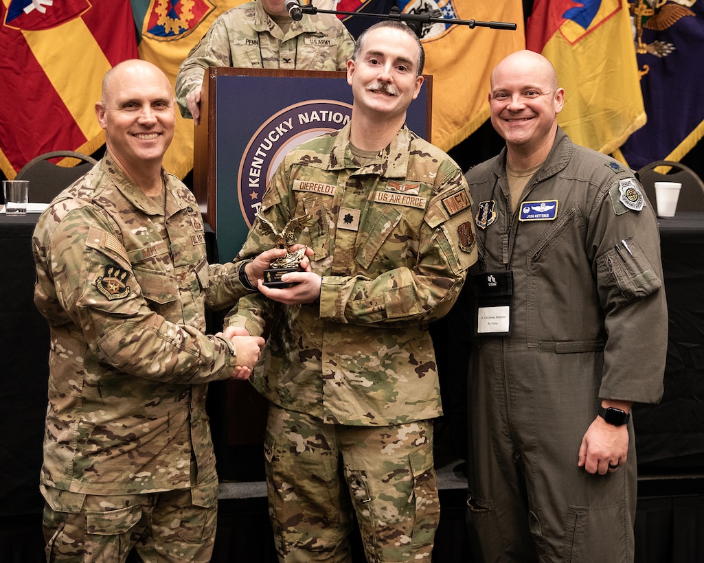 Lt. Col. Dan Dierfeldt, center, a flight surgeon assigned to the Kentucky Air National Guard’s 123rd Medical Group, receives the National Guard Association of Kentucky’s Community Service Award from Col. George Imorde, association president, during the organization’s annual conference in Bowling Green, Ky., Feb. 3, 2024. Dierfeldt was honored for completing 125 hours of voluntary service as a reserve deputy with the Jefferson County Sheriff's Office. (U.S. Army National Guard photo by Maj. Michael Reinersman)