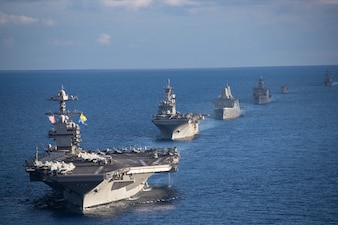 Ships from the Gerald R. Ford Carrier Strike Group (GRFCSG) and the Bataan Amphibious Ready Group (ARG), and Hellenic Navy frigate HS Navarinon (F 461) sail in formation in the Mediterranean Sea, Dec. 31, 2023. The ships from the GRFCSG include the first-in-class aircraft carrier USS Gerald R. Ford (CVN 78) and the Arleigh Burke-class guided-missile USS The Sullivans (DDG 68), USS Bulkeley (DDG 84), and USS Delbert D. Black (DDG 119). The ships from the Bataan ARG include the Wasp-class amphibious assault ship USS Bataan (LHD 5), the San Antonio Class-class amphibious transport dock USS Mesa Verde (LPD 19), Harpers Ferry-class dock landing ship USS Carter Hall (LSD 50). The U.S. maintains forward deployed, ready, and postured forces to deter aggression and support security and stability around the world. (U.S. Navy photo by Mass Communication Specialist 3rd Class Maxwell Orlosky)