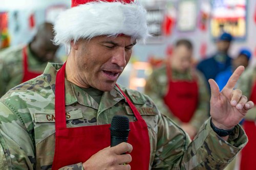 man in christmas hat talks into microphone