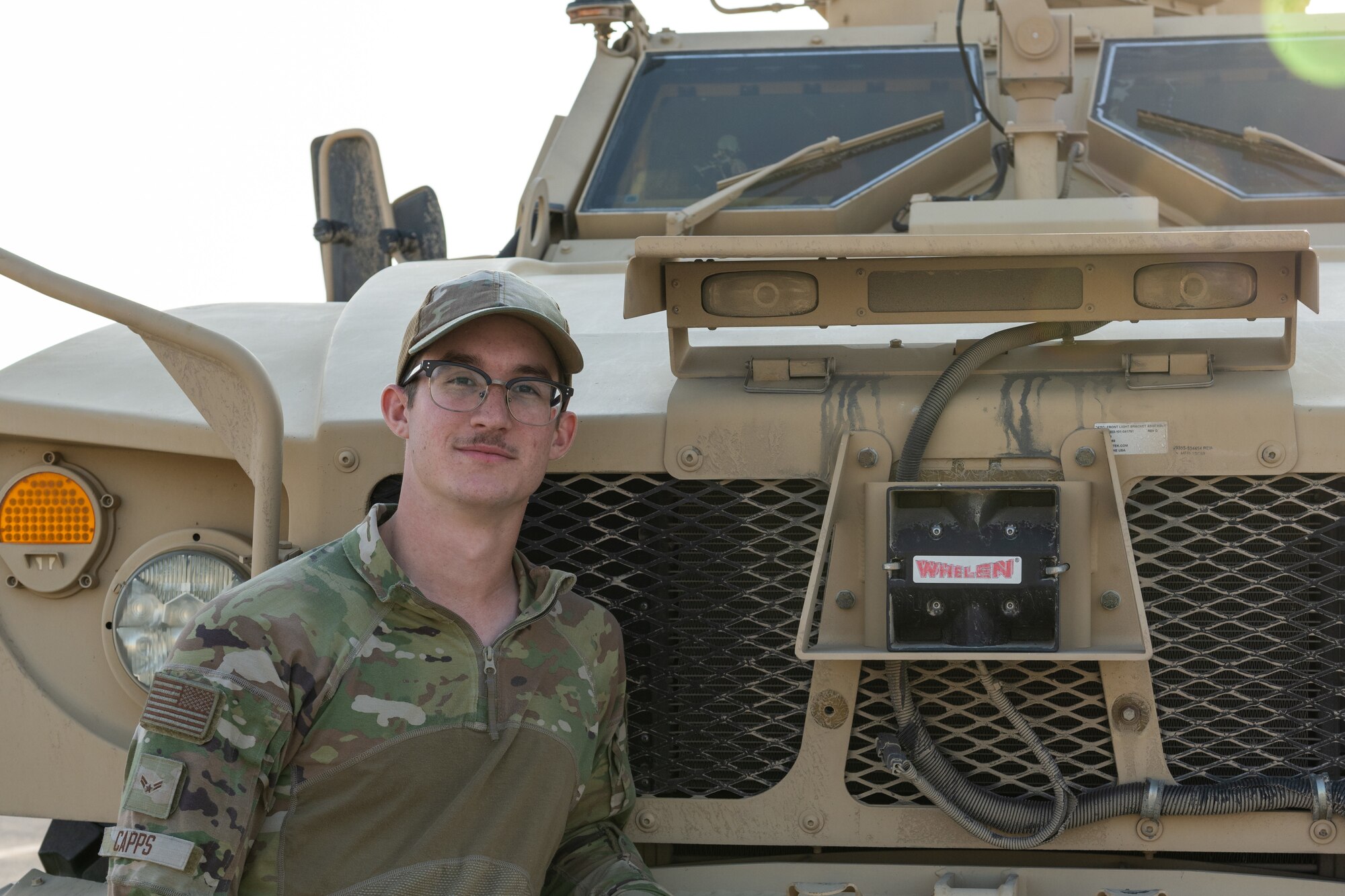 man stands with military vehicle