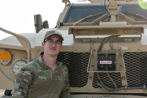 man stands with military vehicle