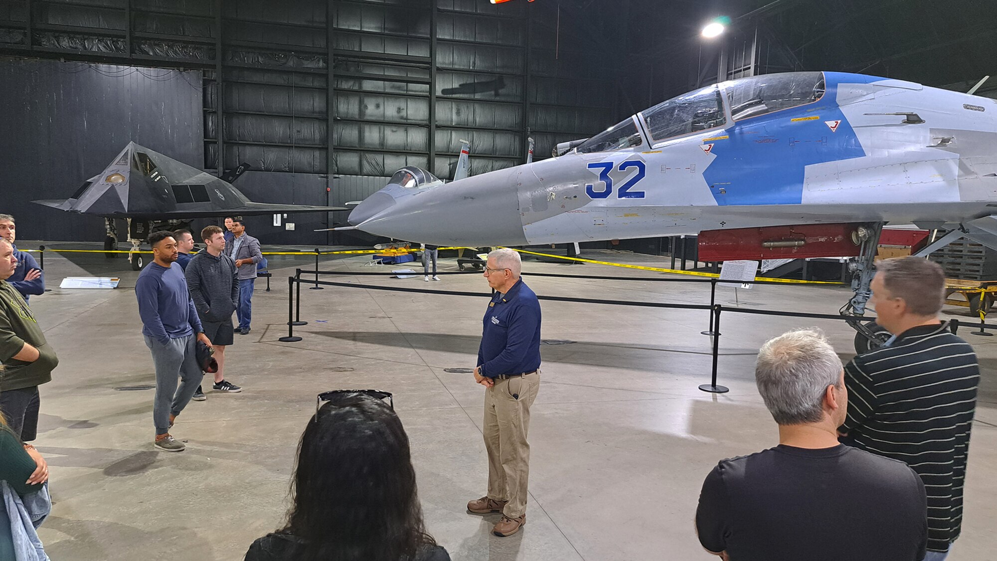 Group of people gathered around a Russian Sukhoi Su-27 Flanker fighter aircraft and a YCGM-121B.