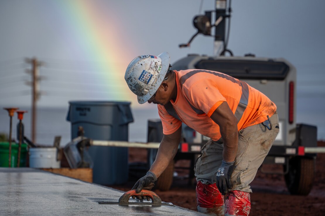 A contractor smooths concrete that is placed in the covered area at the temporary school, Dec. 29, 2023, in Lahaina, Hawaii.