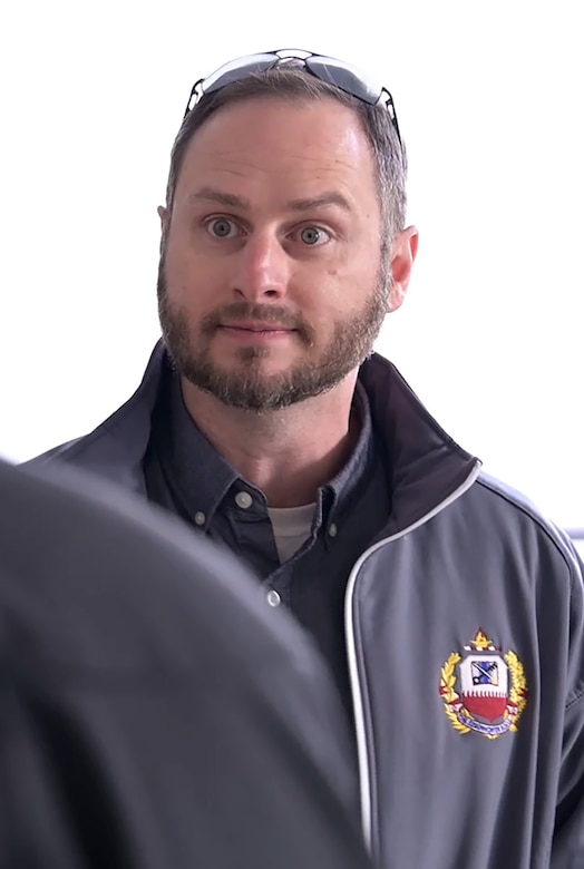 A closeup of a man wearing a gray jacket.