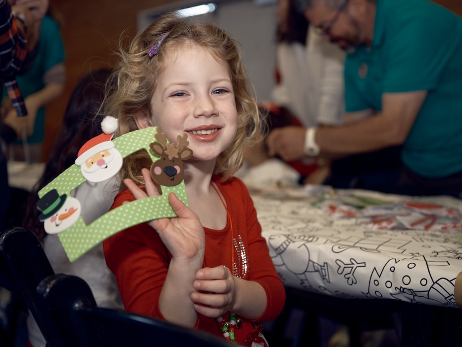 A girl holds up a picture frame she made with Christmas decorations on it in Yokosuka, Japan.