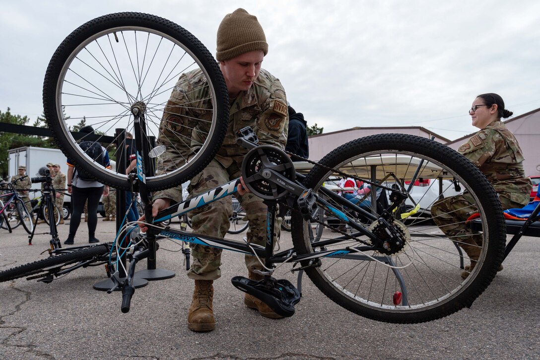 An airman examines a bike.