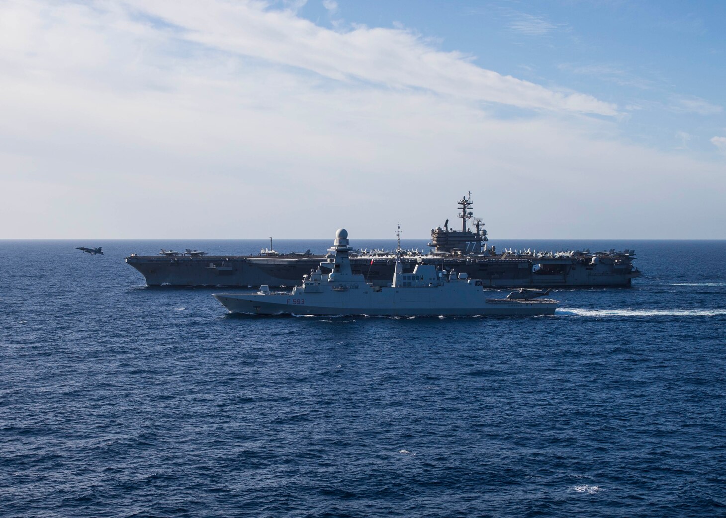 The Nimitz-class aircraft carrier USS George H.W. Bush (CVN 77) sails alongside the Italian Navy Carlo Bergamini-class frigate ITS Carabiniere (F 593) while an F/A-18 Super Hornet aircraft, assigned to Carrier Air Wing (CVW) 7, takes off during combined operations in the Tyrrhenian Sea, Dec. 6, 2022.