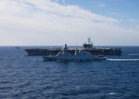 The Nimitz-class aircraft carrier USS George H.W. Bush (CVN 77) sails alongside the Italian Navy Carlo Bergamini-class frigate ITS Carabiniere (F 593) while an F/A-18 Super Hornet aircraft, assigned to Carrier Air Wing (CVW) 7, takes off during combined operations in the Tyrrhenian Sea, Dec. 6, 2022.